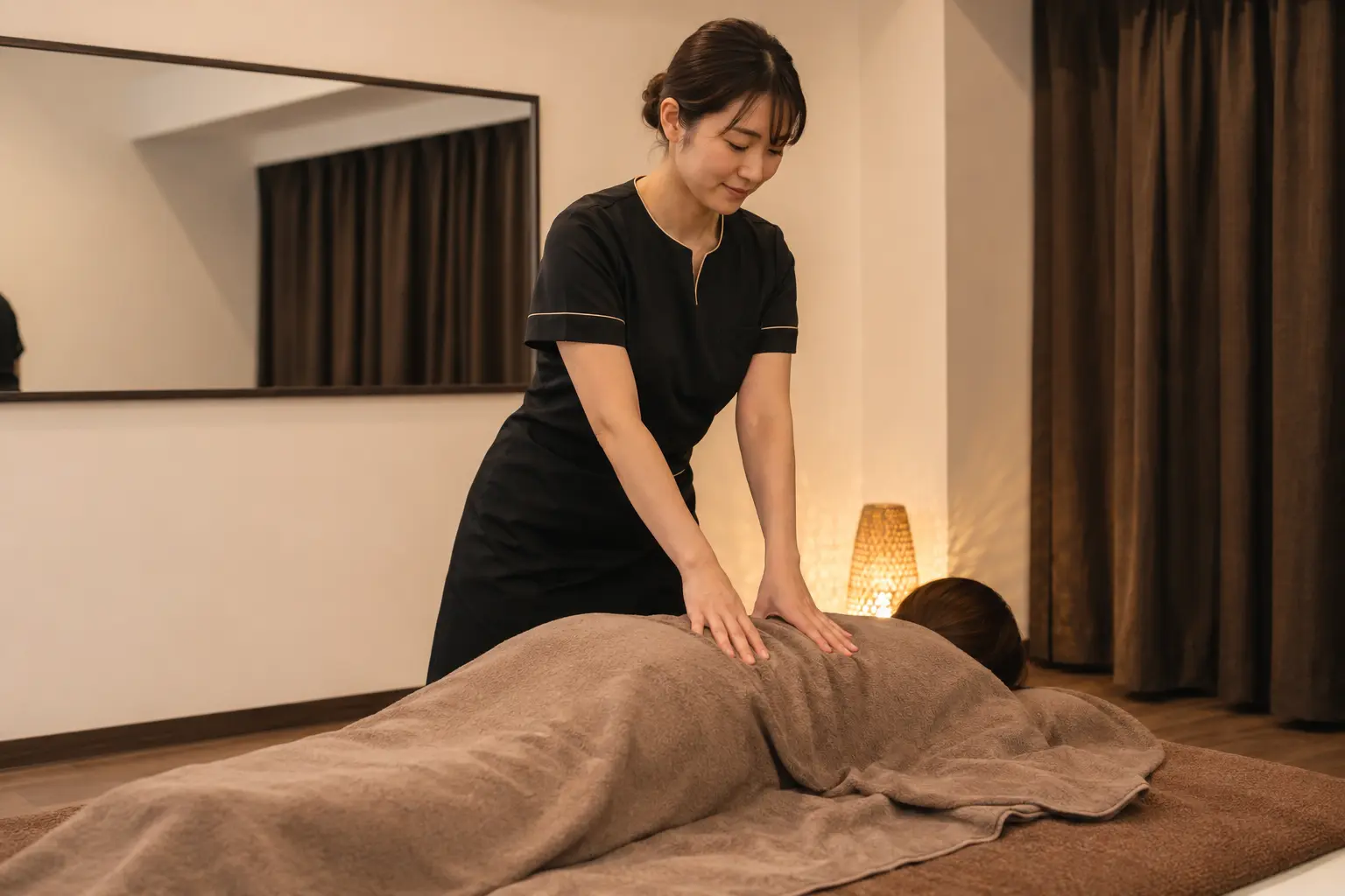タオルの上から丁寧に施術するRelaxation Hugの女性セラピスト